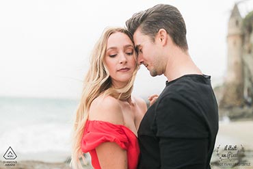 Couple amoureux sous la pluie sur la plage en californie, à Newport beach, devant une tour abandonnée