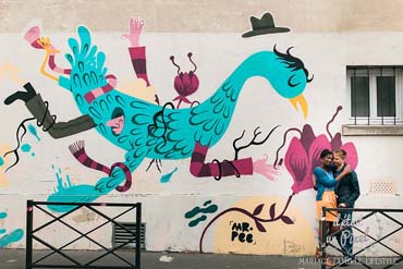 Couple devant un mur avec graffiti, à Paris