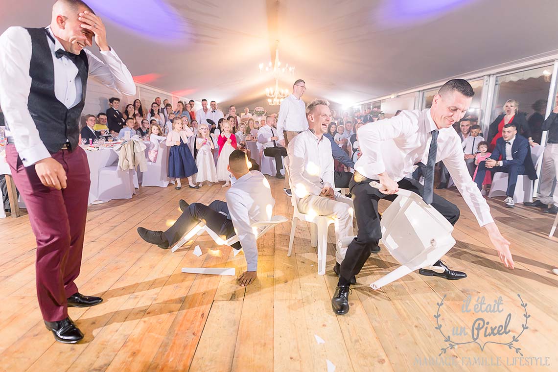 Guests breaking chairs during a game during the wedding dinner while the groom takes his head in his hand