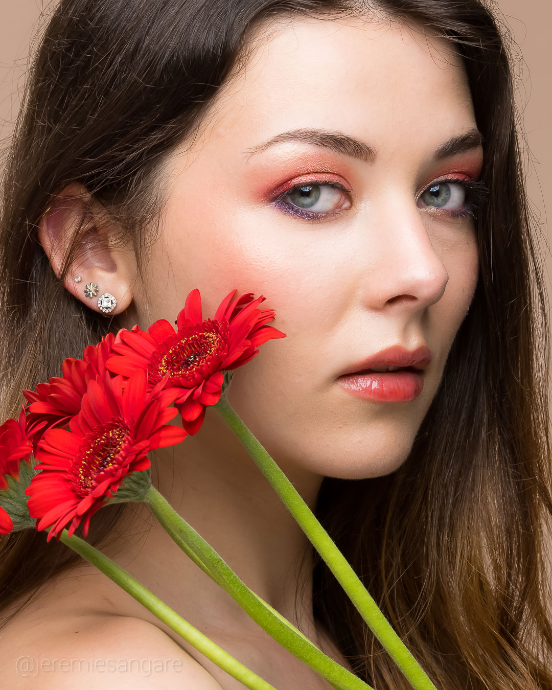 Portrait studio sur d'une jeune femme avec des fleurs pendant un shooting photo beauté