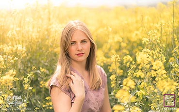Portrait d'une jeune femme dans un champ de colza jaune pendant un shooting photo