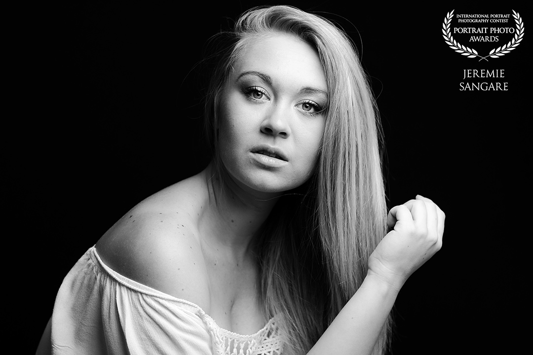 Portrait low key sombre noir et blanc d'une jeune mannequin blonde pendant un shooting photo portrait