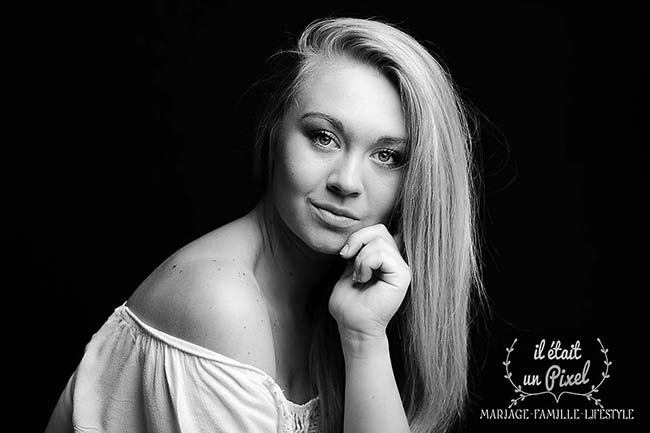 Portrait low key sombre noir et blanc d'une jeune mannequin blonde pendant un shooting photo portrait