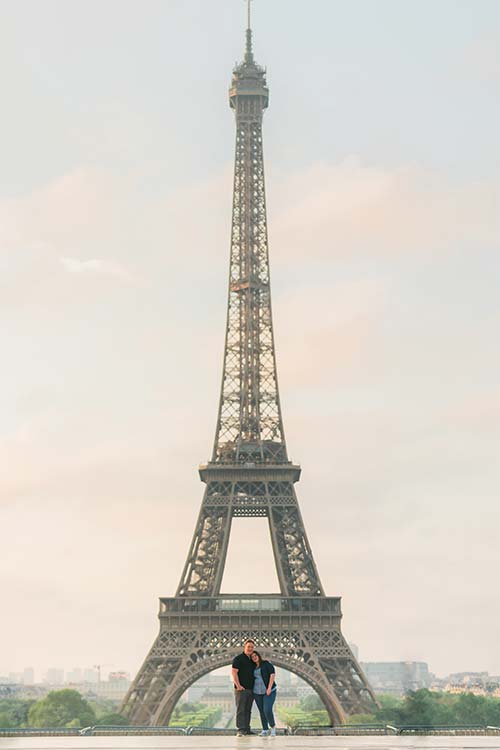 Engagement session of an american couple in front of the Eiffel Tower (Paris, France) with the soft golden light of a summer sunrise