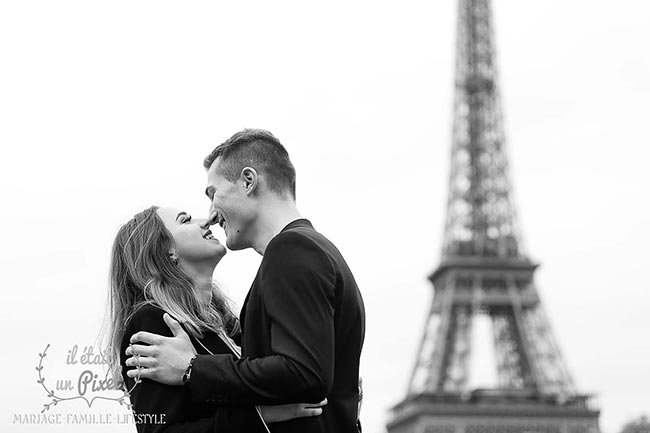 Couple en noir et blanc devant la Tour Eiffel pendant une séance engagement