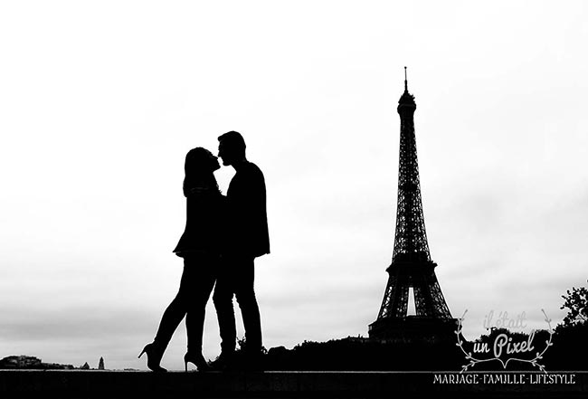 Couple en silhouette devant la Tour Eiffel pendant une séance engagement