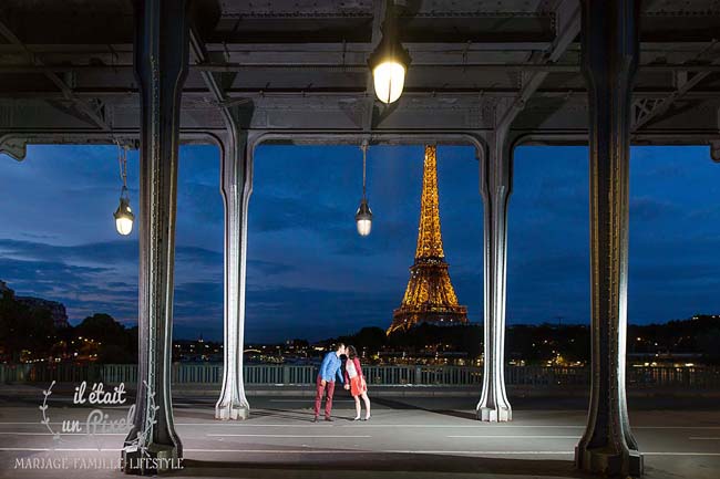 Photo de nuit d'un couple sous le pont Bir Hakeim à Paris