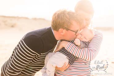 Family embracing on the beach during a photo session at sunrise