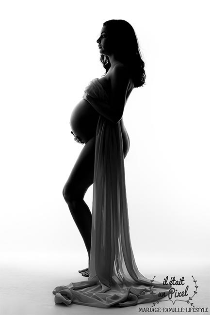 Photo de grossesse Noir et Blanc en studio avec voilage et jeux d'ombres et lumière