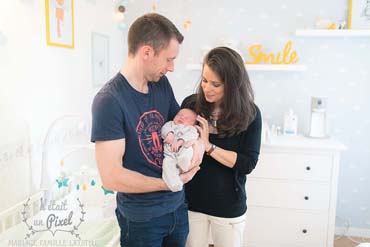 Photo lifestyle à domicile d'un bébé dans sa chambre lors d'un shooting naissance