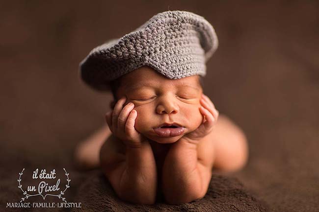 Photo d'un bébé sur les coudes lors d'un shooting naissance type newborn posing en studio