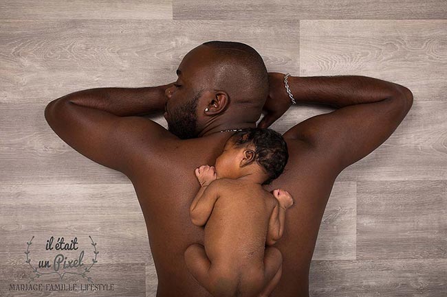 Photo d'un bébé sur le dos de son papa lors d'un shooting naissance