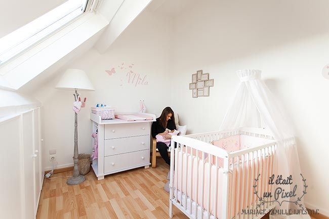 Photo lifestyle à domicile d'un bébé au biberon dans sa chambre lors d'un shooting naissance
