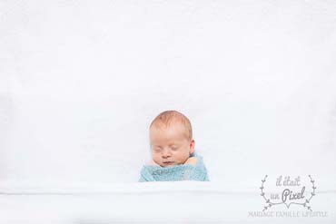 Photo d'un bébé enveloppé lors d'un shooting naissance type newborn posing en studio