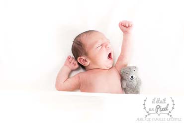 Photo d'un bébé qui baille lors d'un shooting naissance 