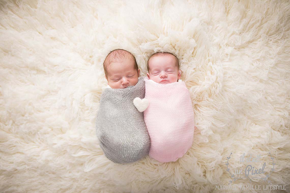 Photo de bébés jumeaux sur flokati lors d'un shooting naissance type newborn posing en studio