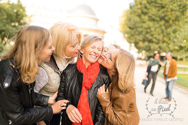 Photo de groupe lors d'un shooting EVJF au Parc Monceau à Paris avec les participantes embrassant la future mariée