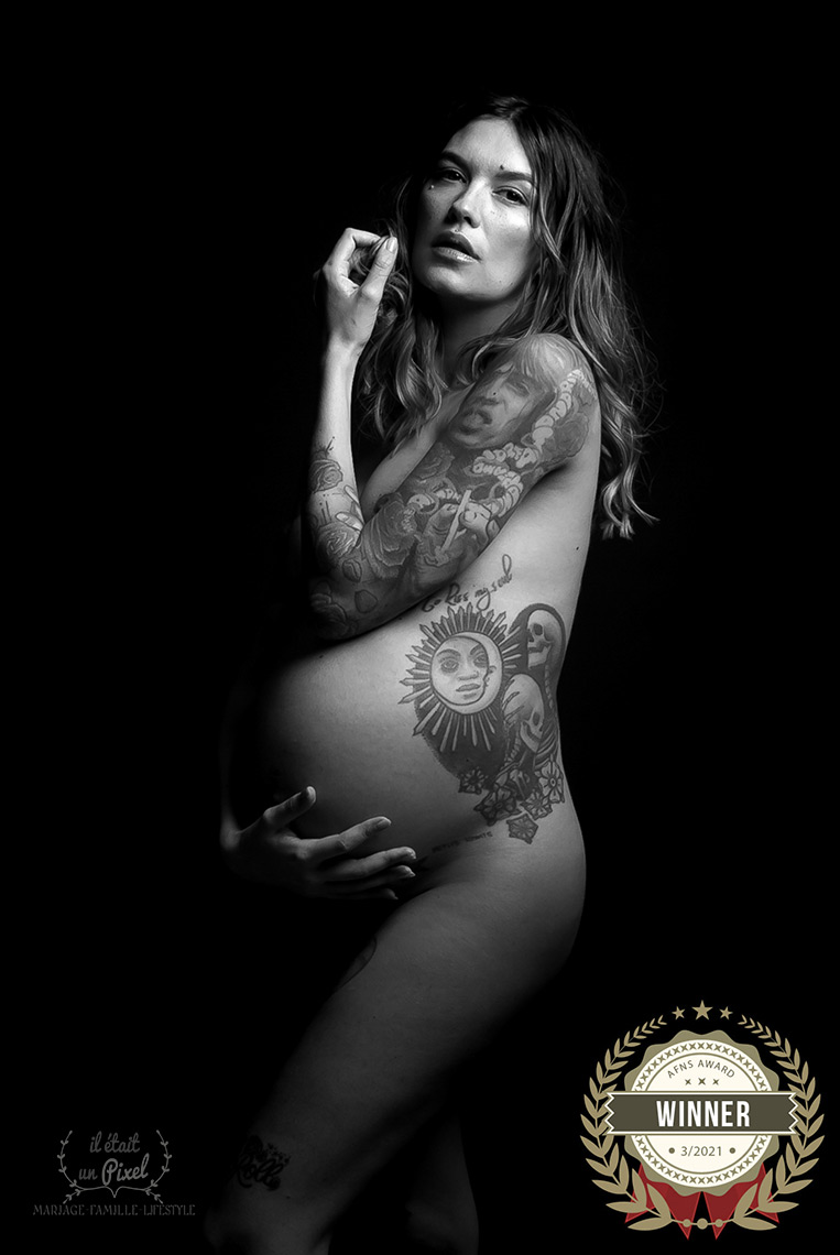 Portrait noir et blanc d'une future maman avec tatouages