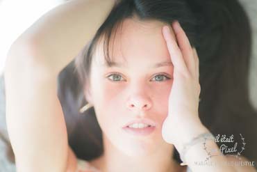 Portrait avec lumière douce du visage d'une jeune femme allongée pendant une séance photo